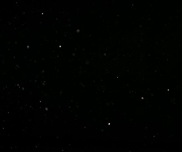 Dark textured background with golden dust particles